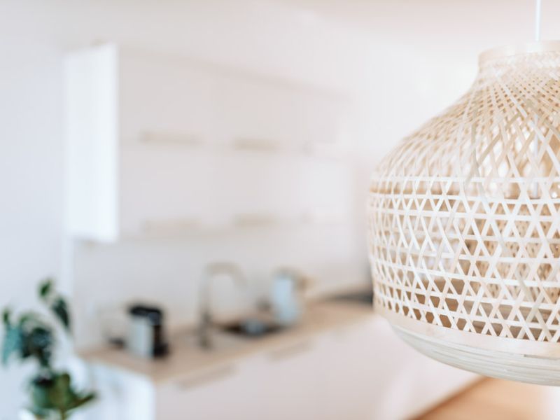 Geflochtene Hängelampe als Designelement in der offenen Küche der Deichstadt-Apartments