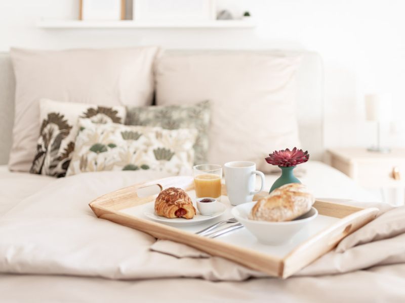 Frühstückstablett mit Croissants, Saft und Kaffee auf dem Bett in der Ferienwohnung Neuwied