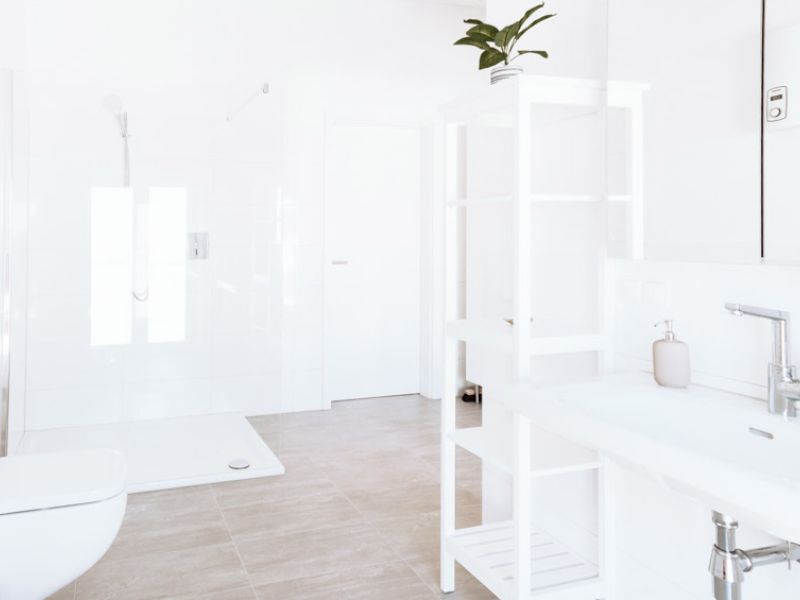 Weiß gefliestes Badezimmer mit Regalen in der Ferienwohnung Neuwied