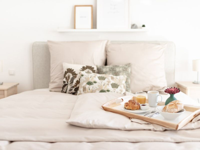 Schlafzimmer mit Doppelbett, Frühstückstablett und Dekokissen in der Ferienwohnung Neuwied