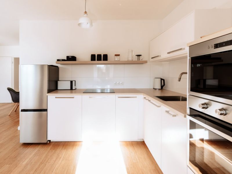 Moderne Küche mit weißen Fronten und kompletter Ausstattung in den Deichstadt-Apartments