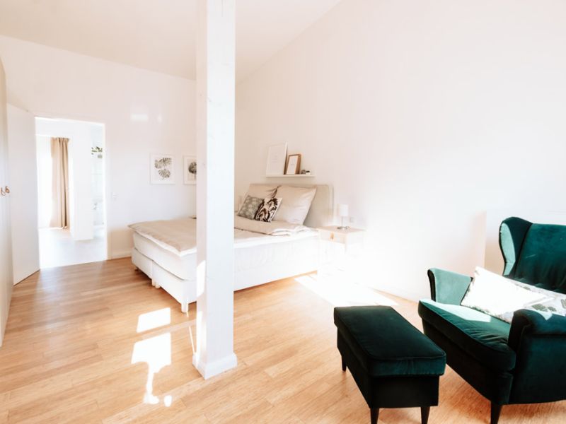 Geräumiges Schlafzimmer mit Sitzgelegenheit in den Deichstadt-Apartments